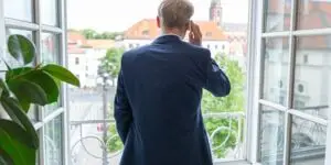 Rechtsanwalt Torsten Bebensee im Anzug am Telefon vor einem Fenster